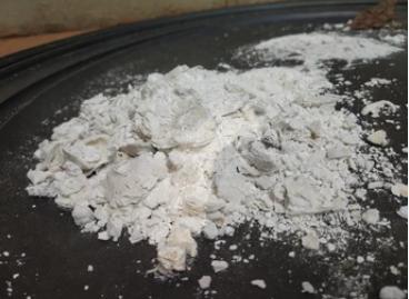 Calcium hypochlorite present as solid particles on a black surface